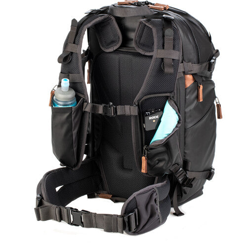 Sleek side profile of the Shimoda V2 25 pack showing its tripod and water bottle pockets.