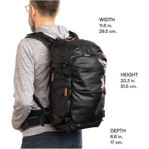 Backpack attached to a rolling suitcase via its luggage pass-through sleeve.
