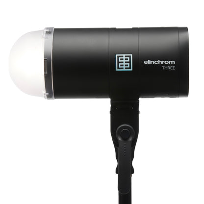 Photographer using Elinchrom THREE with a color gel for creative effects